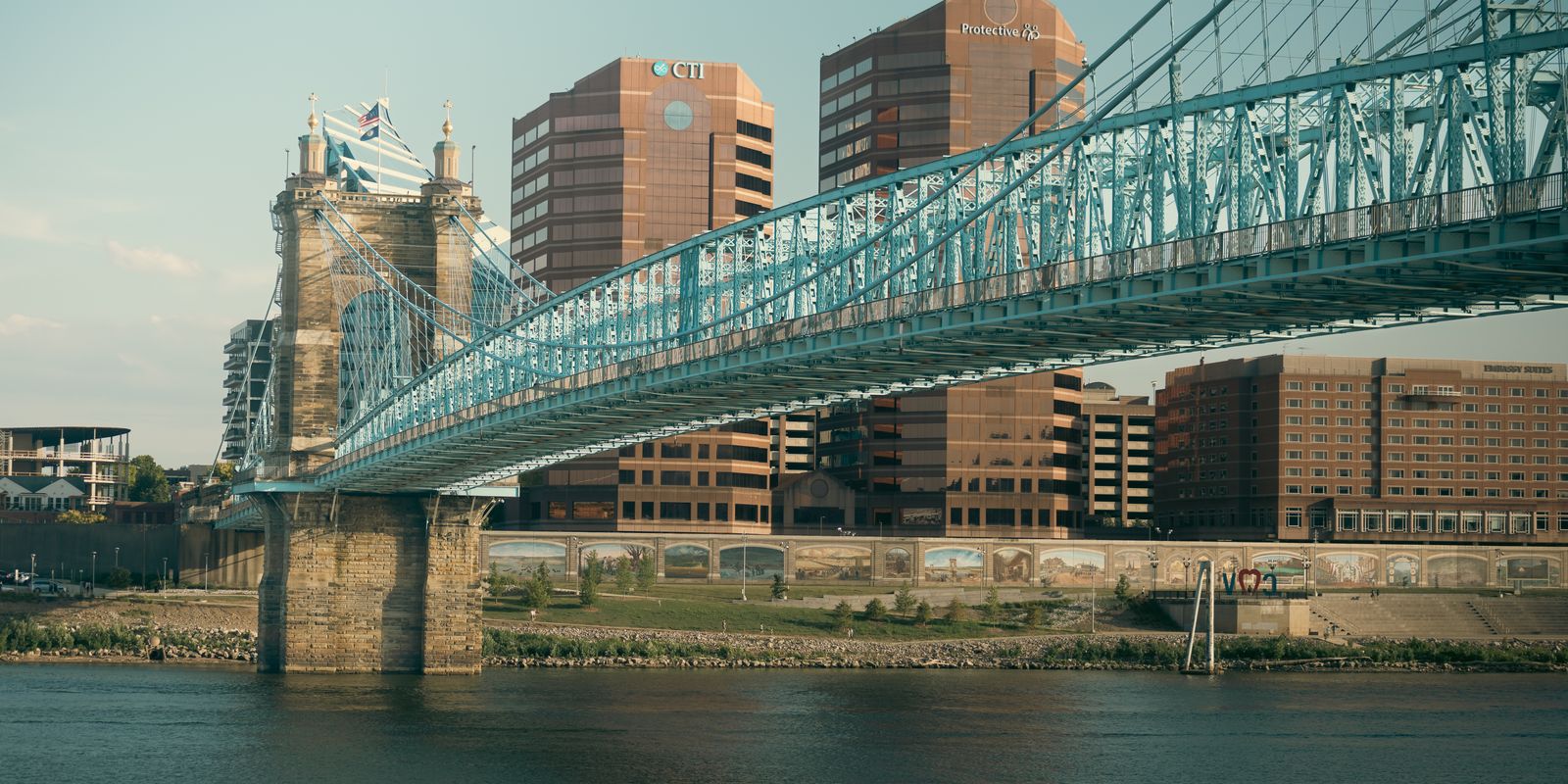 A suspension bridge over the Ohio River at sunset
