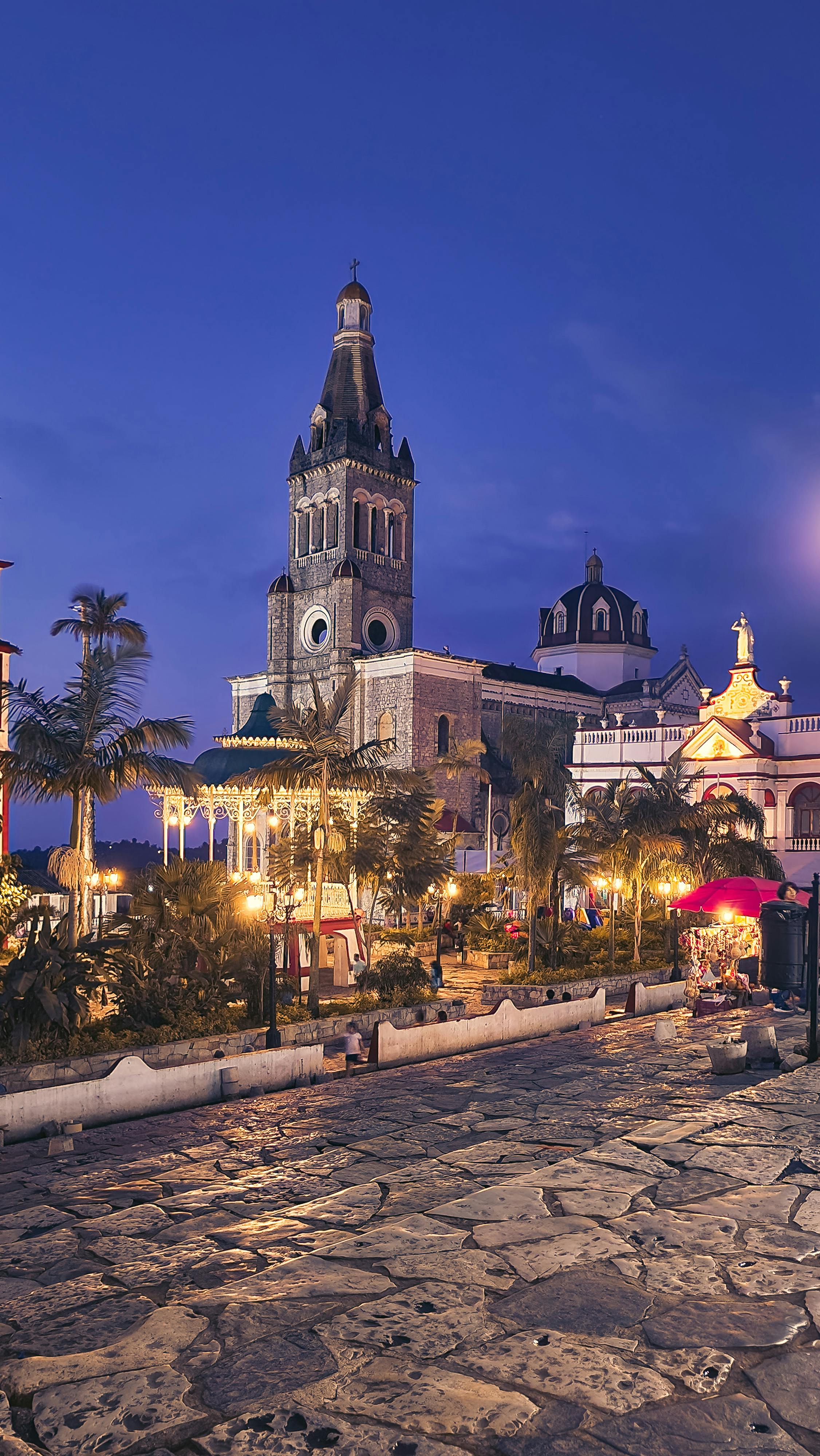 a city street with a church and a clock tower