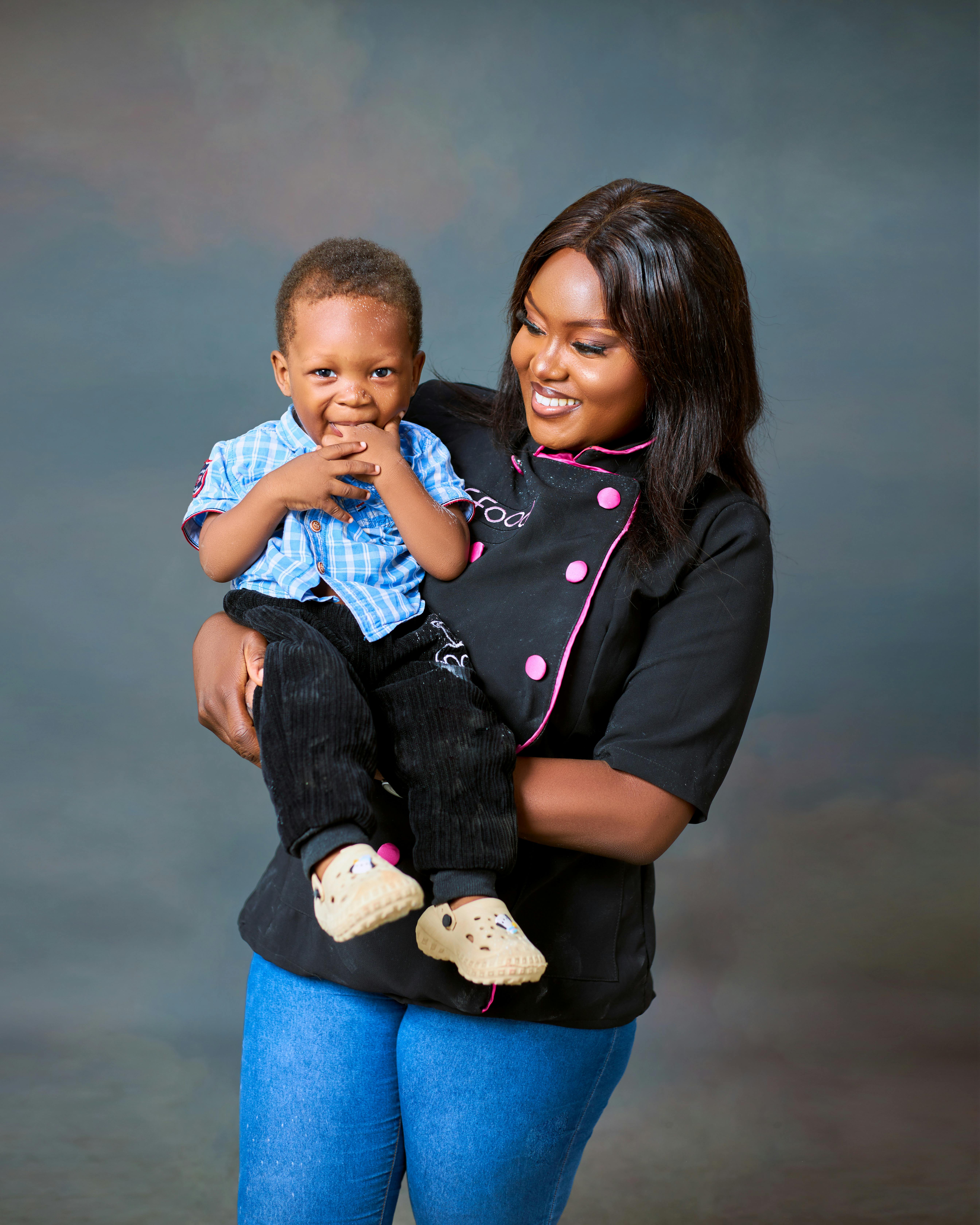 a woman in a chef s jacket holding a baby