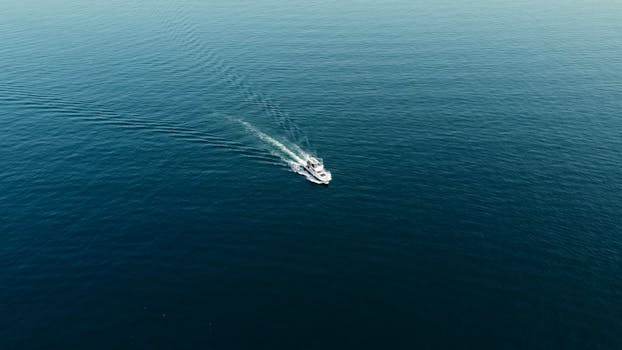 Drone shot of a lone boat sailing on the blue sea near Heybeliada, Istanbul.