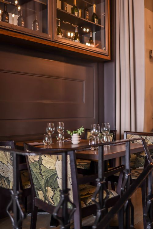 Free Sophisticated dining room featuring elegant tableware and plush seating in a luxurious setting. Stock Photo
