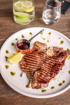 Juicy grilled steak served with lemon and a rich sauce, perfect for a gourmet meal.