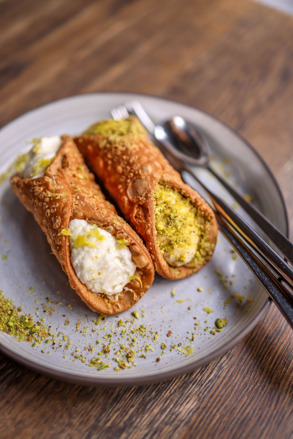 Cannoli filled with ricotta and dipped in chopped pistachio
