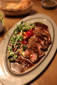 Deliciously plated beef steak with fresh vegetables and rich sauce.