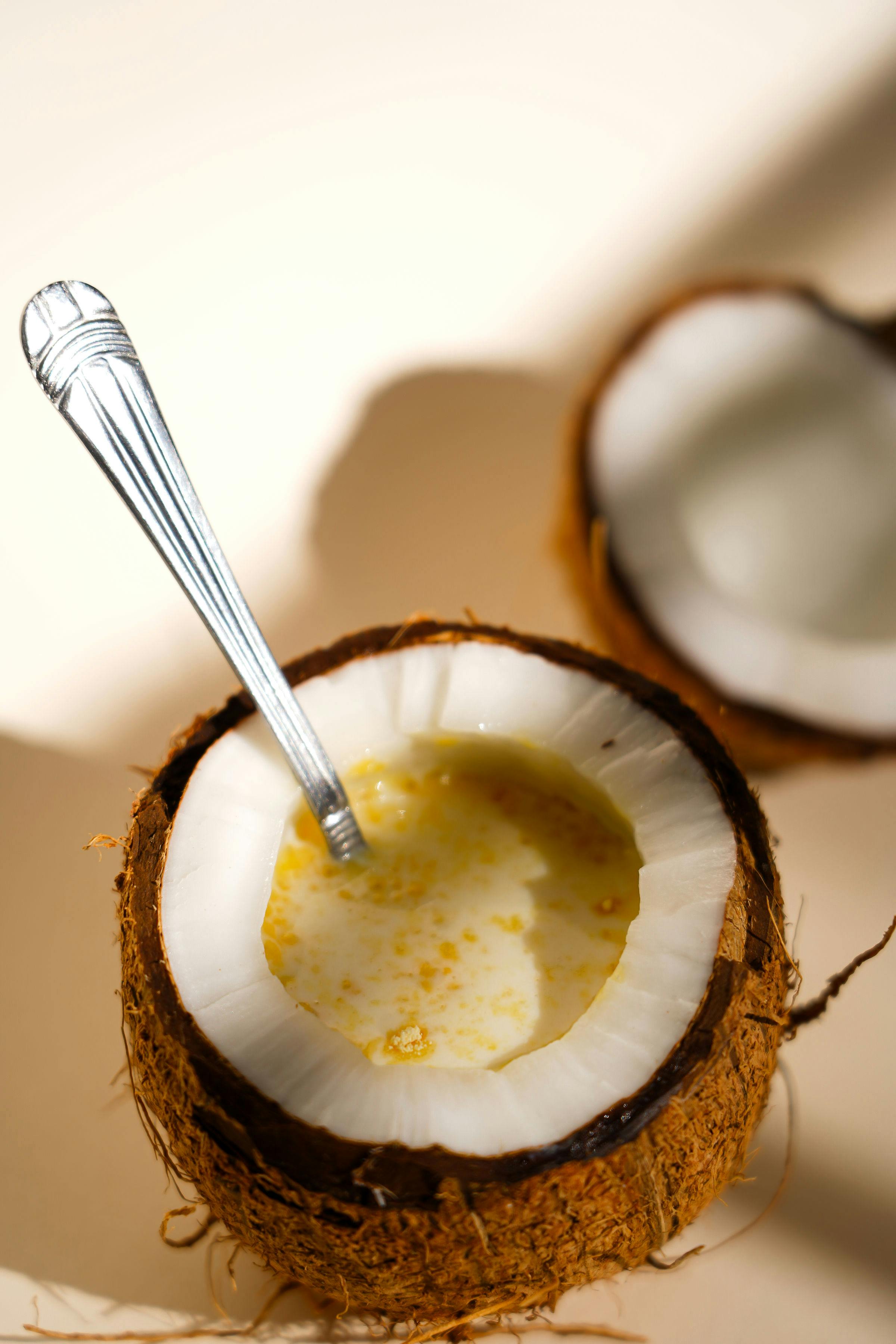 Fresh coconut filled with cream and spoon, perfect for a tropical breakfast.
