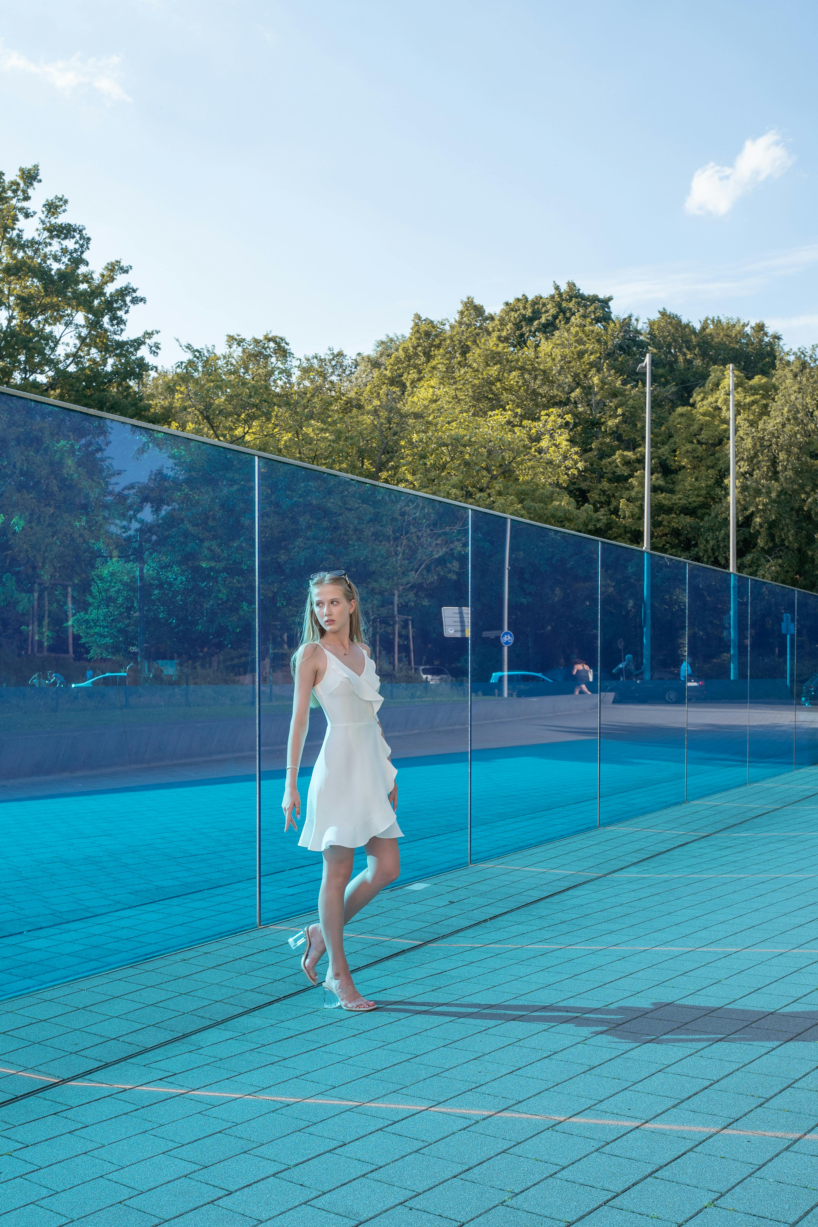 a woman in a white dress is standing on a tennis court