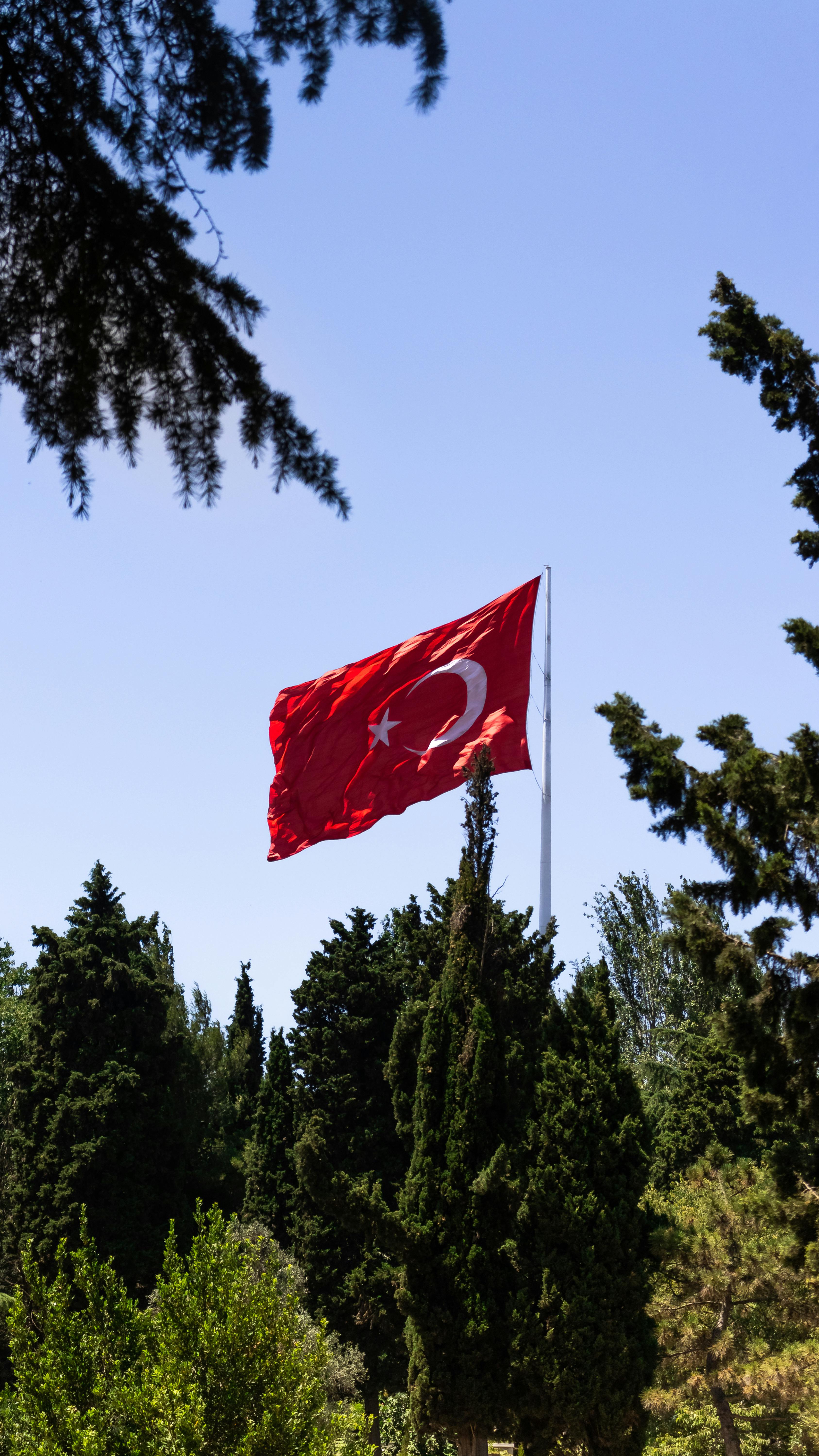 a turkish flag flies in the wind