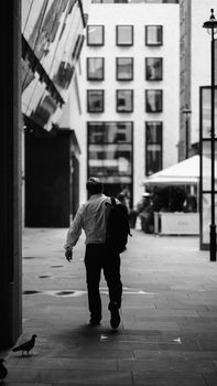 Monochrome photo of a man walking on a city street in London, capturing urban life.