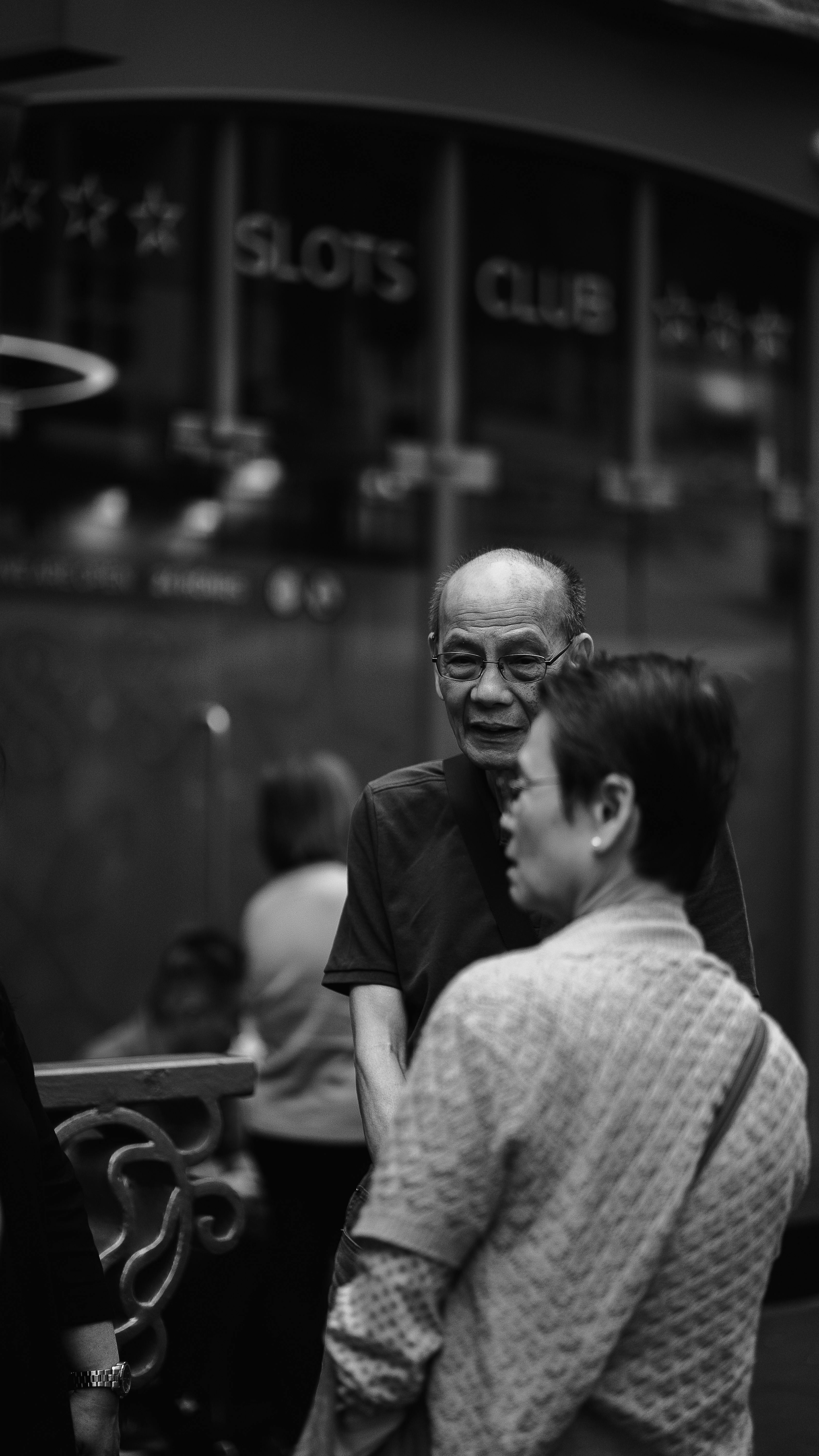 a man and woman are talking to each other in a black and white photo