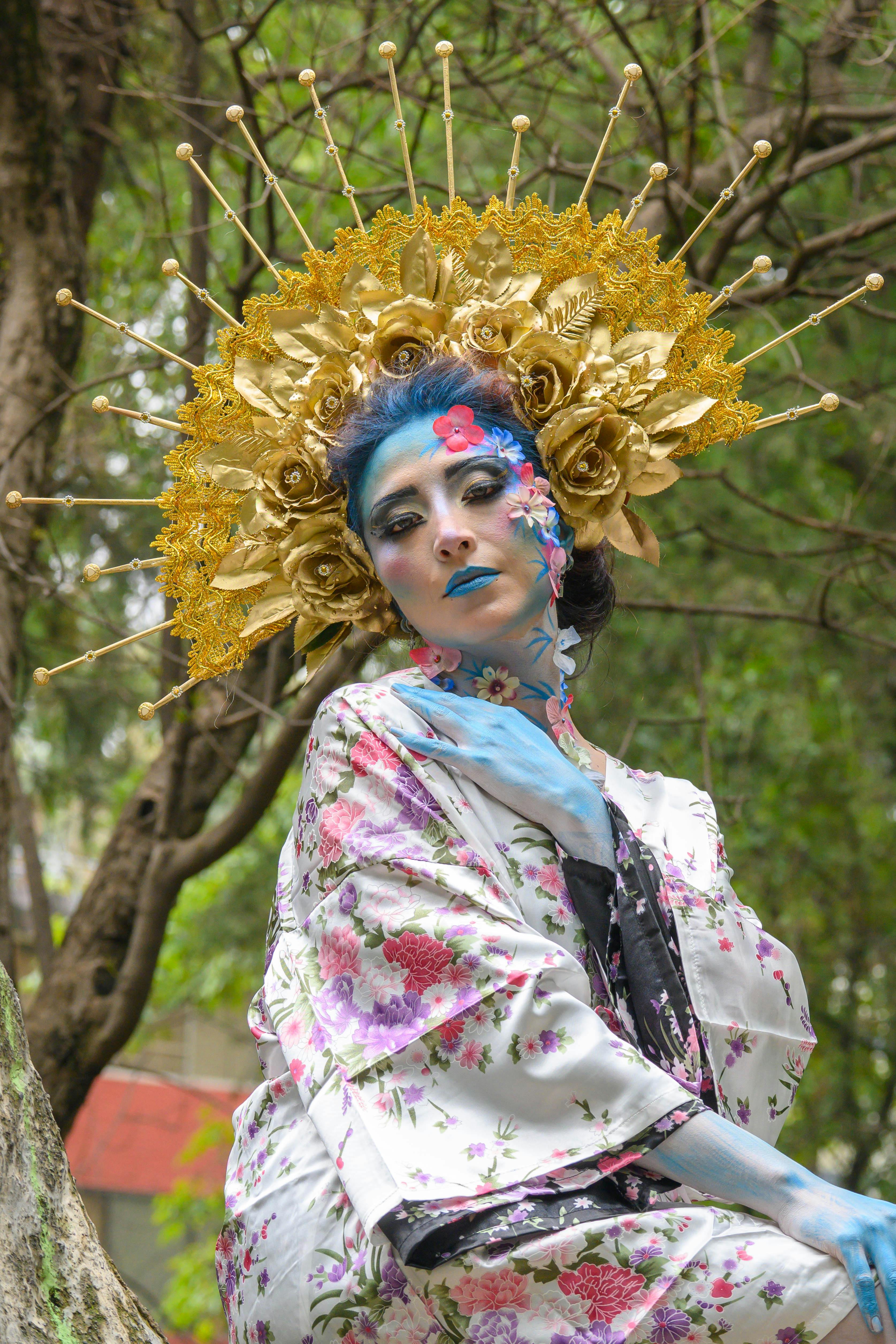 a woman with blue face paint and gold headdress