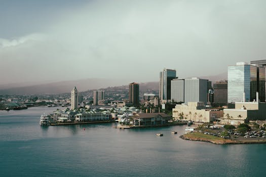 A scenic view of Honolulu's cityscape with waterfront buildings and a vibrant skyline.