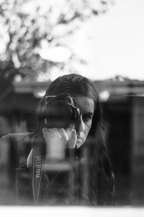 Free Black and white portrait of a woman capturing her reflection with a camera. Stock Photo