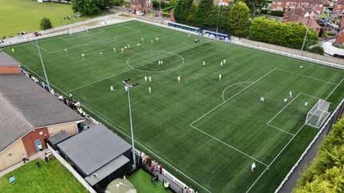 Free Aerial photo of a soccer match in Fitzwilliam, England showing active players and spectators. Stock Photo