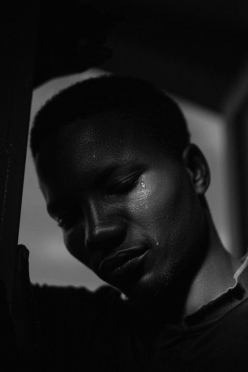 Free Dramatic black and white portrait of a young man with a tear, creating a somber mood. Stock Photo