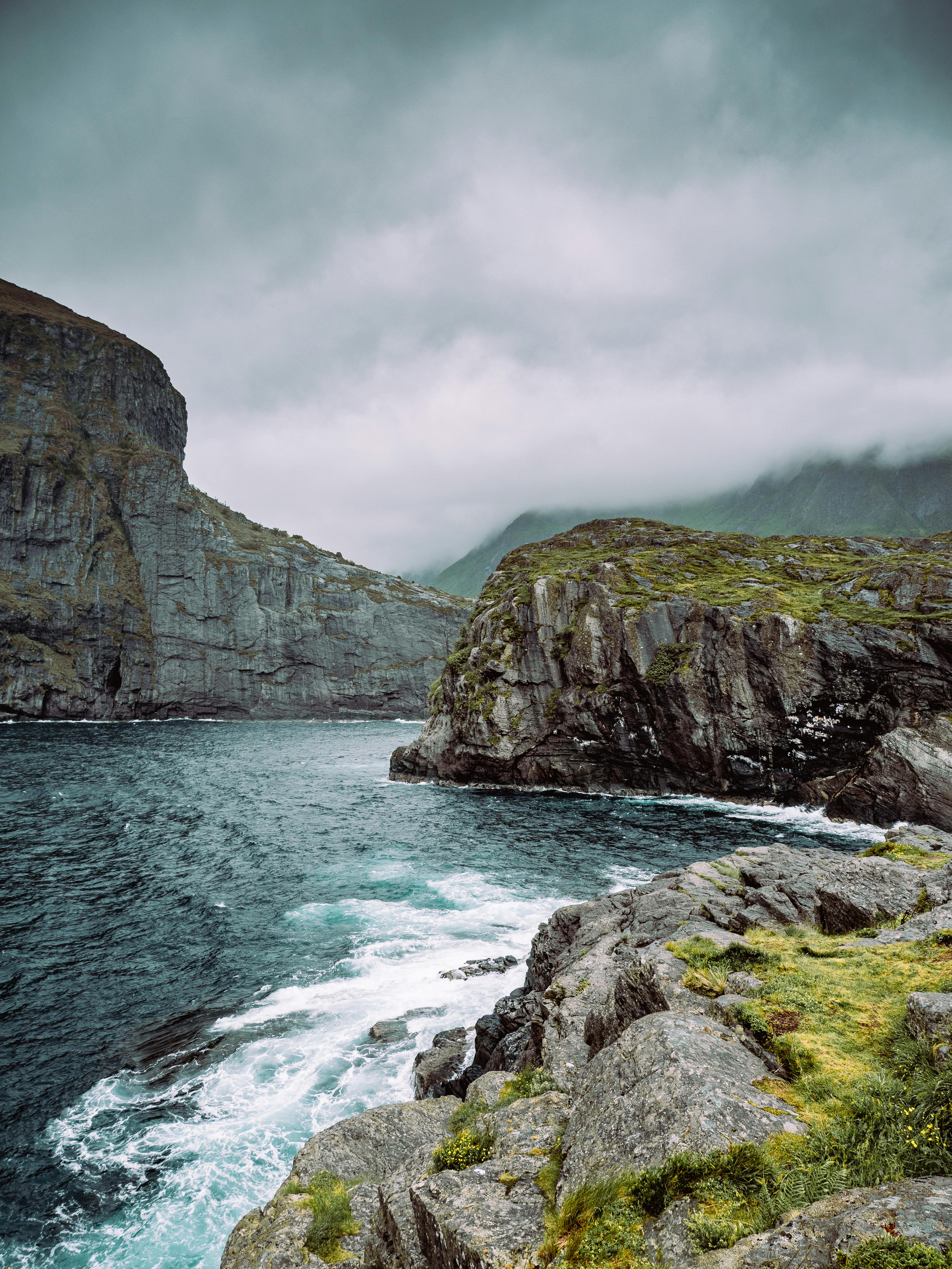 Majestic rocky coastline under a moody, overcast sky, showcasing nature's rugged beauty.