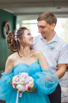 Happy bride and groom embracing indoors, enjoying a romantic moment together.