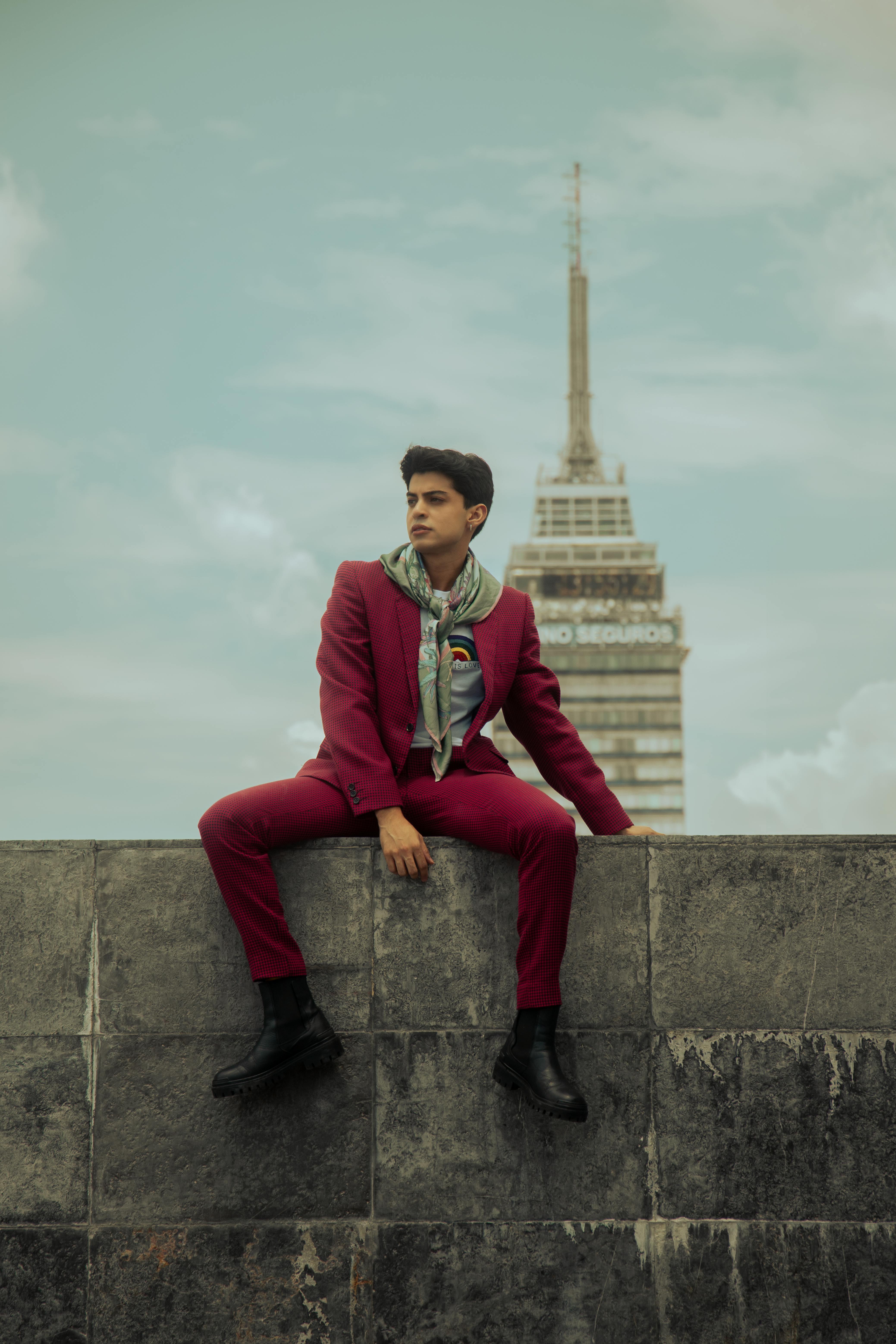 Free Stylish man in red suit posing with tower in background, Mexico City. Stock Photo