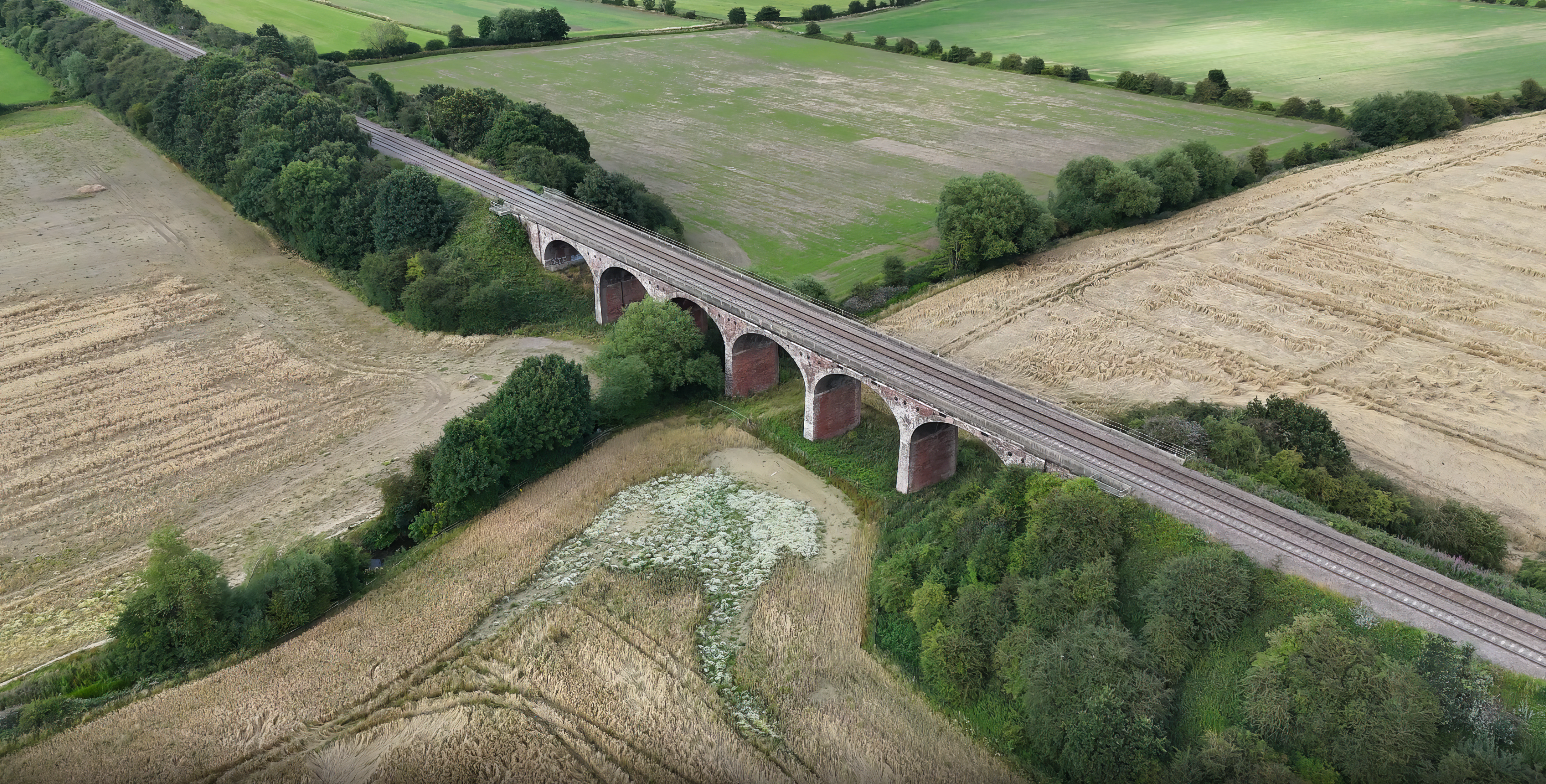 Aerial view of Ackworth Viaduct surrounded by lush fields and trees in England.