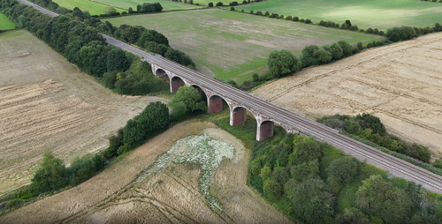 Free Aerial view of Ackworth Viaduct surrounded by lush fields and trees in England. Stock Photo