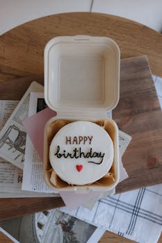 A minimalist birthday cake in an eco-friendly box, perfect for celebrations.