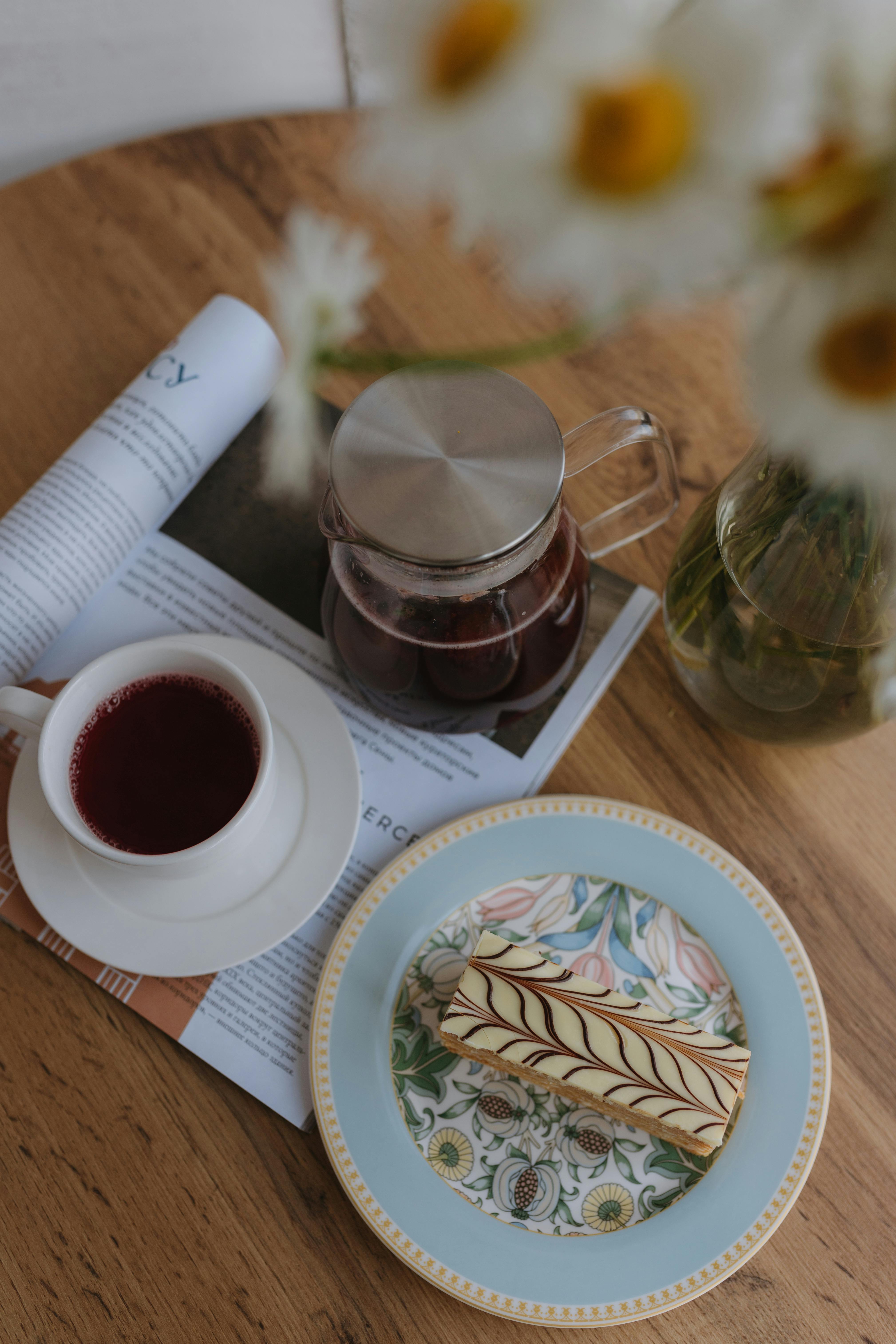 a cup of coffee and a plate of cake on a table