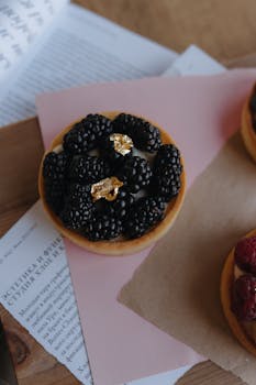 A beautifully presented blackberry tartlet on a rustic table, showcasing a luxurious dessert.