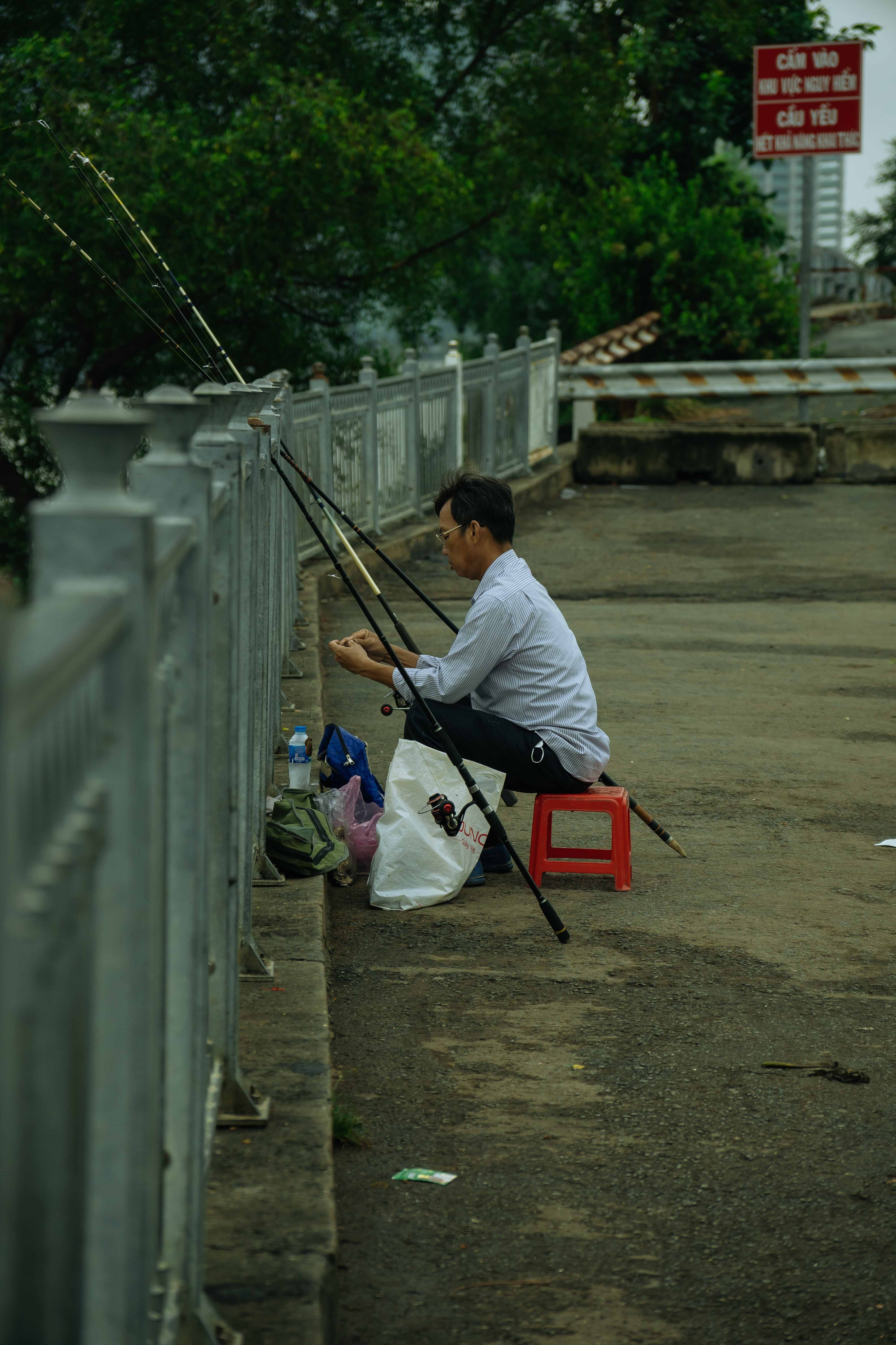 Side View of a Man Fishing from a Bridge · Free Stock Photo