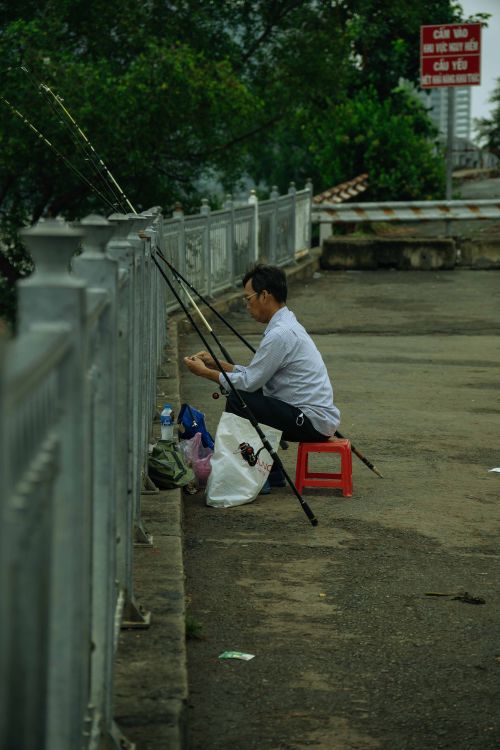 Side View of a Man Fishing from a Bridge · Free Stock Photo