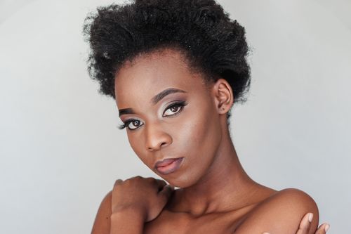 Free Elegant studio portrait of a young woman with natural afro hair and artistic makeup. Stock Photo