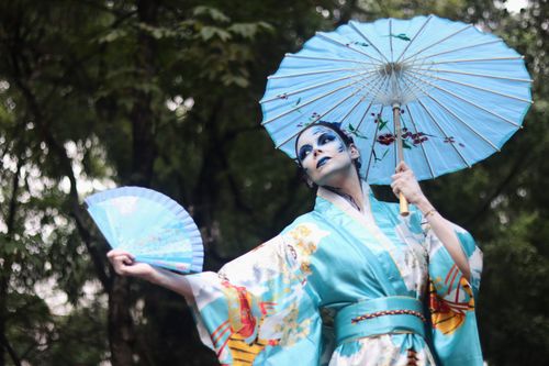Free A vibrant portrait of a woman in a traditional kimono with parasol, outdoors. Stock Photo