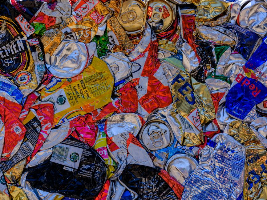 A vibrant display of crushed aluminum cans showcasing recycling art with a colorful pattern.