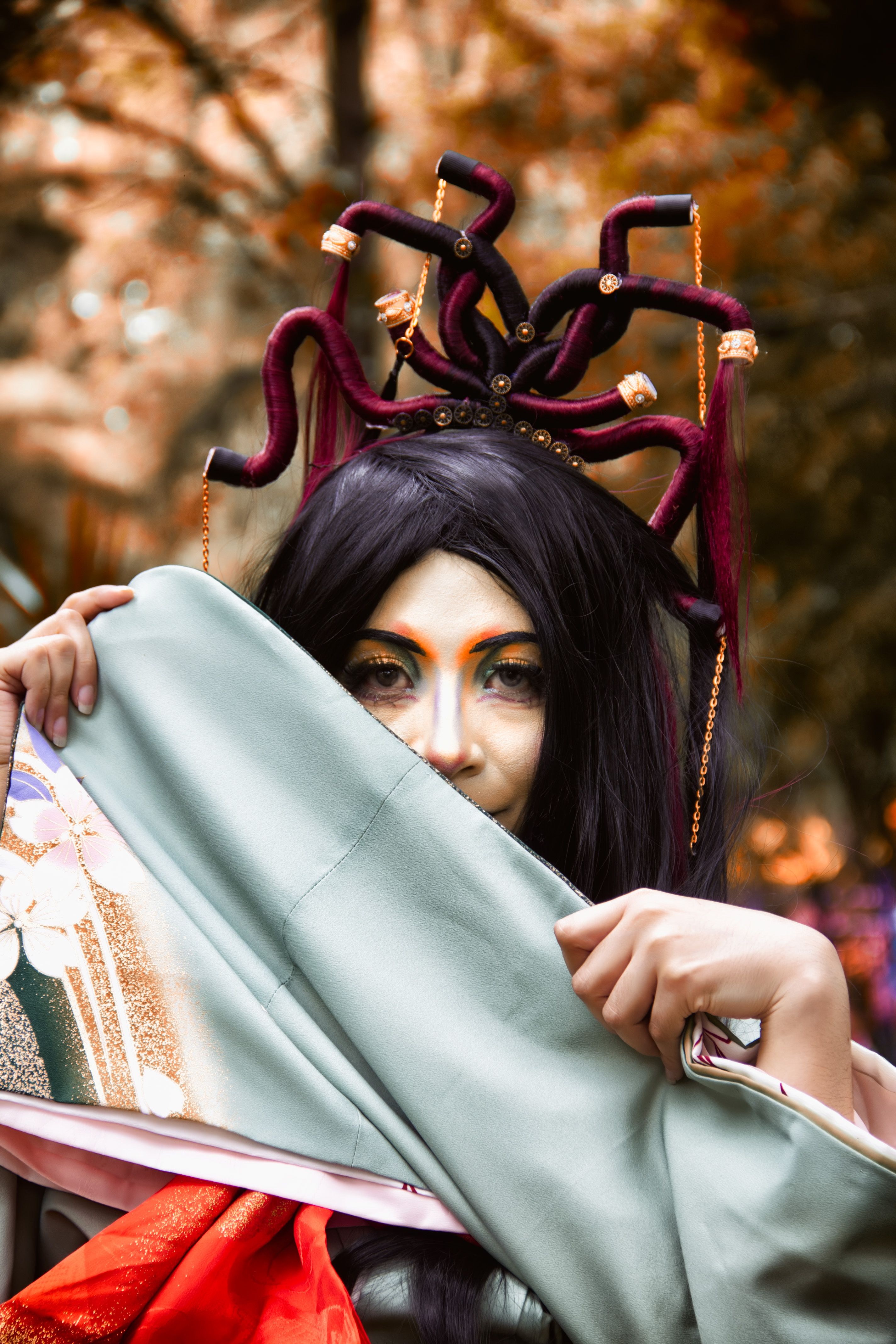 A captivating Medusa-themed cosplay portrait outdoors in a vibrant autumn setting. Perfect for fantasy enthusiasts.