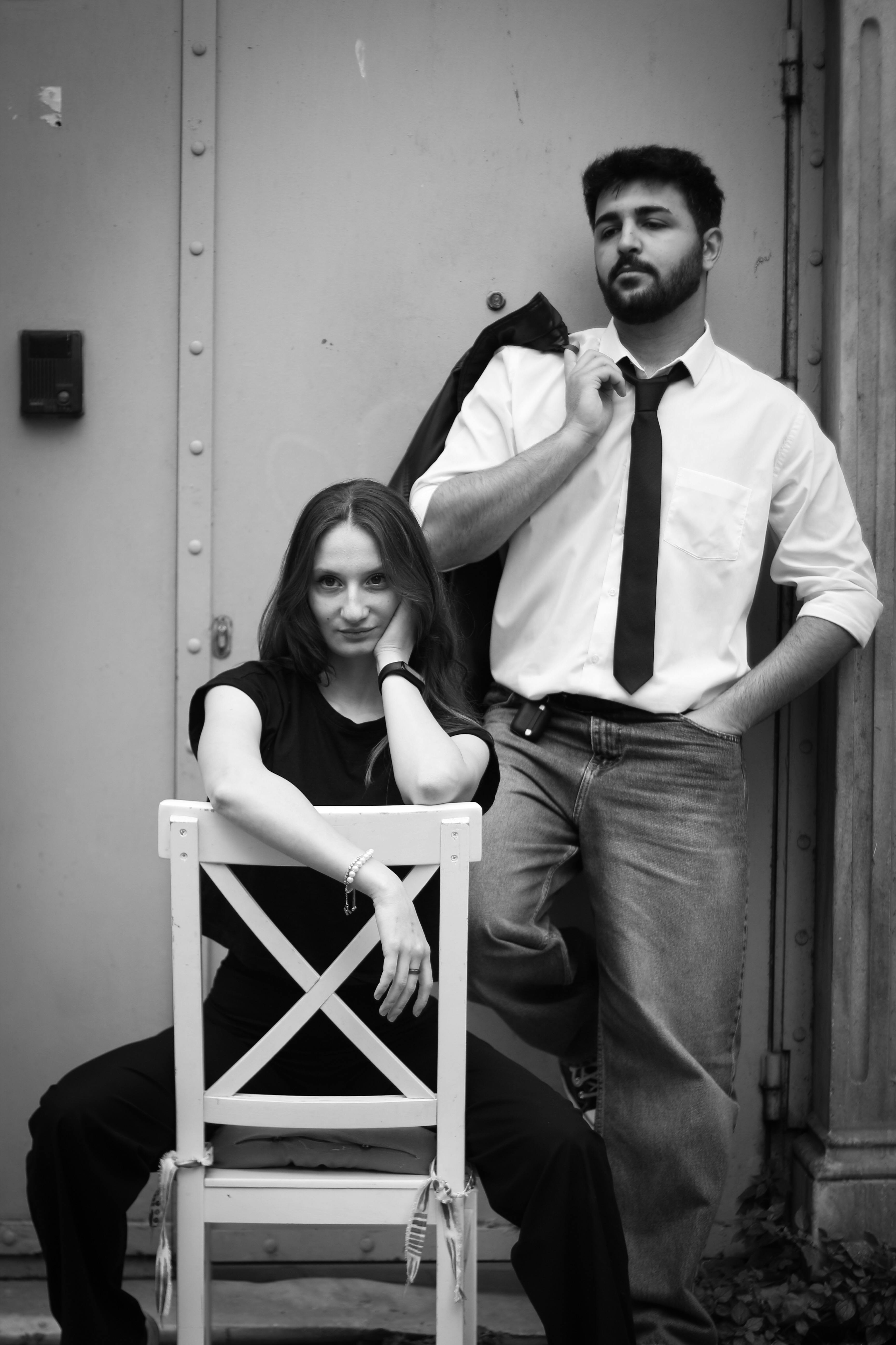 a man and woman posing for a photo in front of a chair