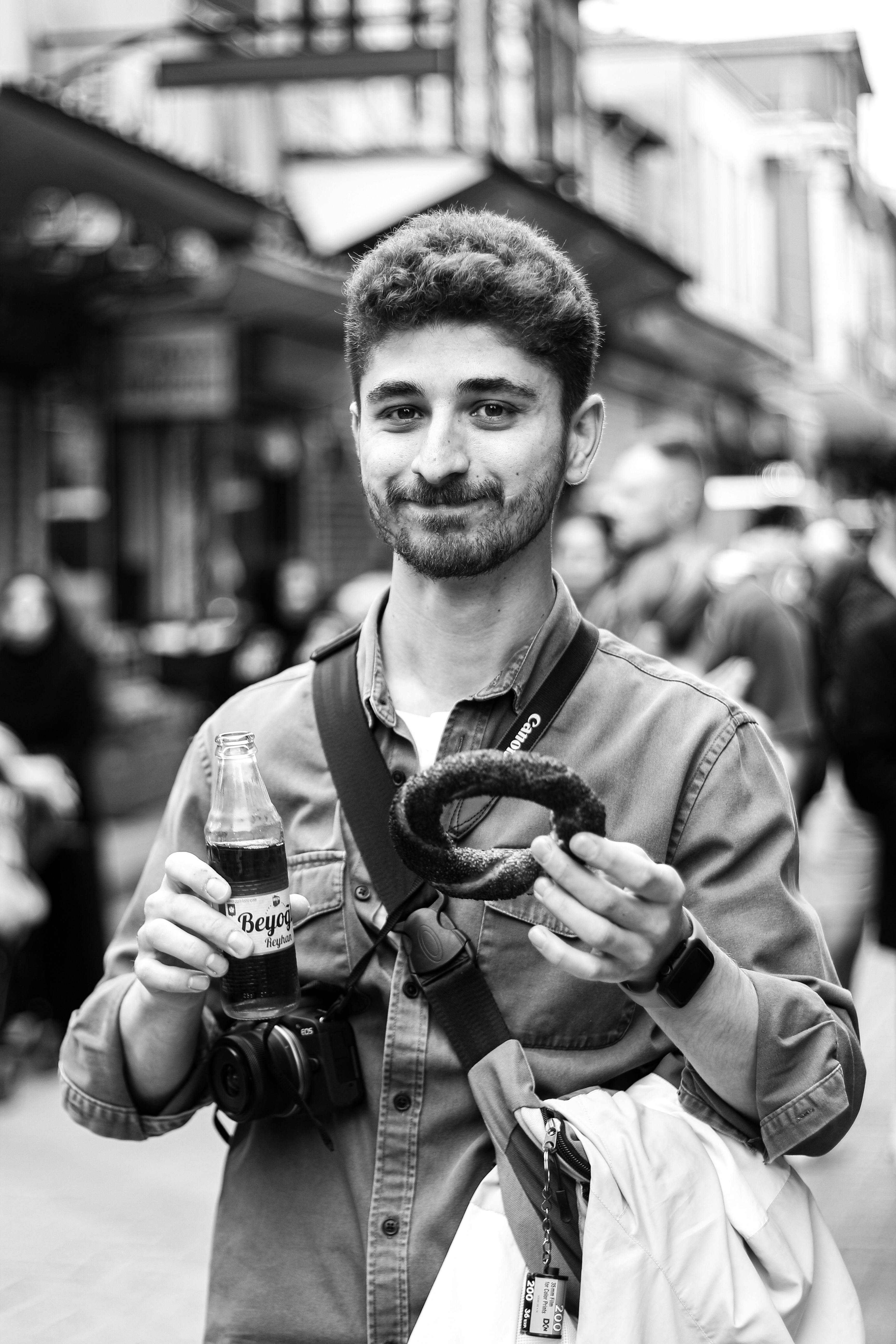 a man holding a bagel and a bottle of water