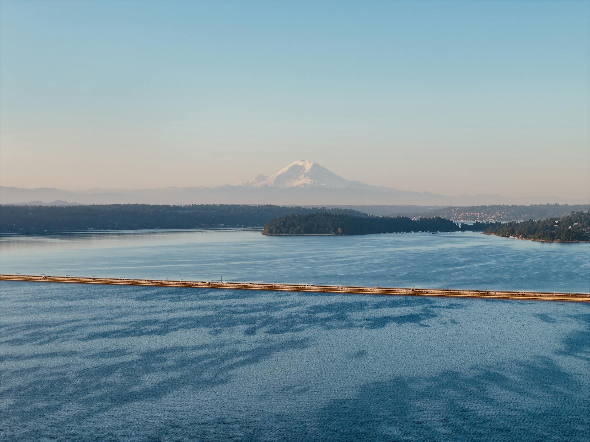 A serene landscape of Lake Washington and Mount Rainier at sunset from Seattle, WA.