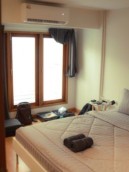 A cozy and modern bedroom interior in Bangkok with natural light and minimalistic decor.