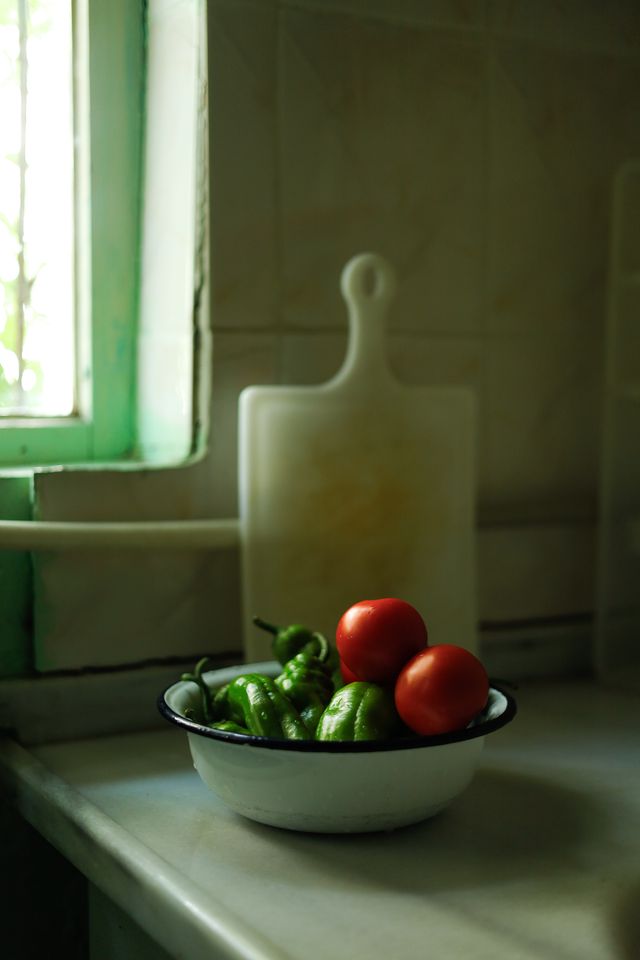 Peppers and tomatoes in a bowl by a window — photo by Esra Erdem on Pexels