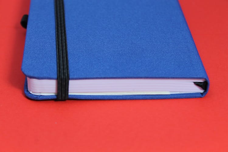 Blue Notebook On Red Surface