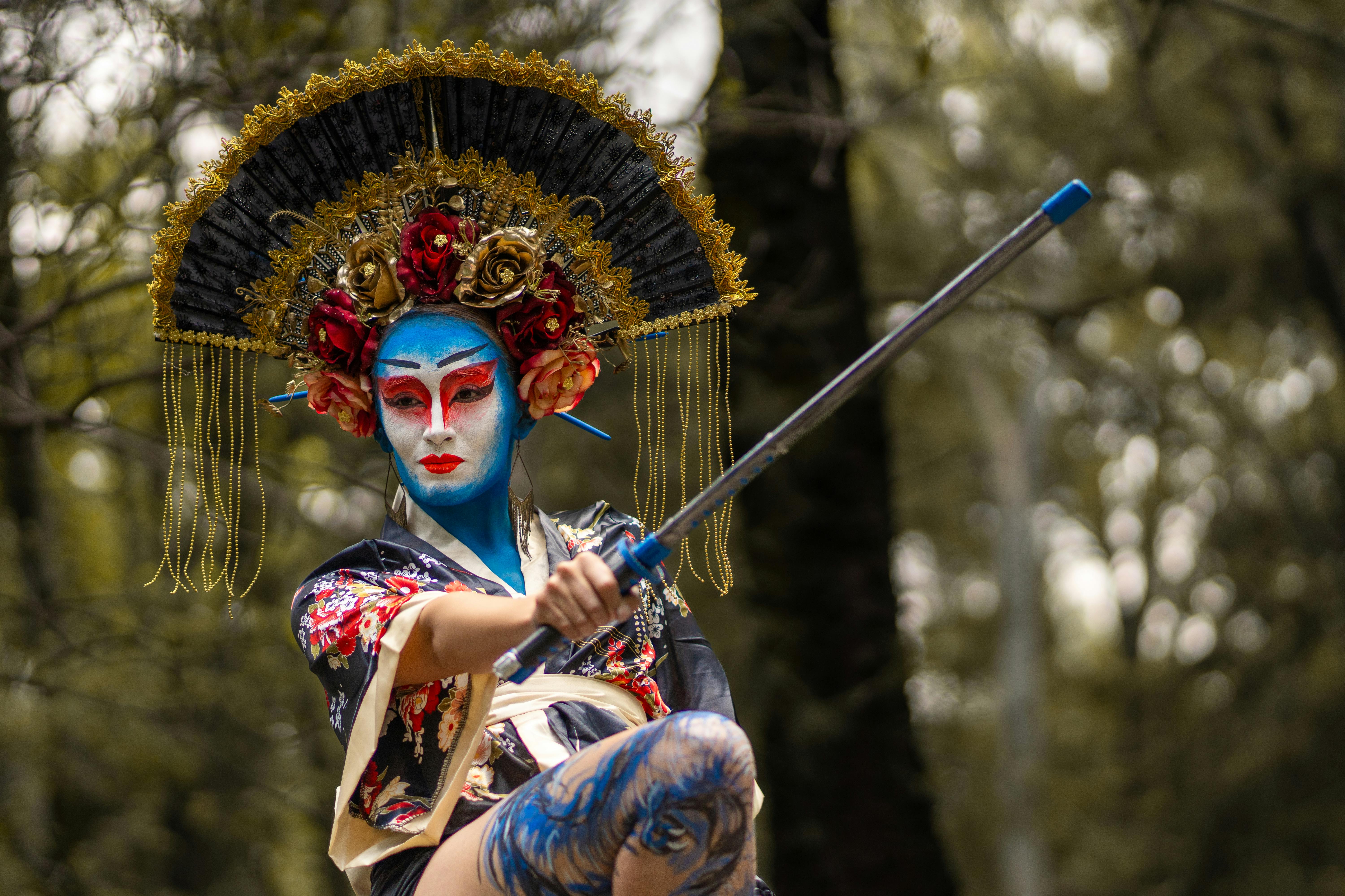 a woman in a blue and white costume holding a stick