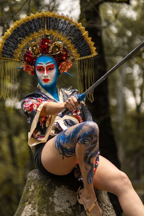 Free Striking portrait of a performer in colorful costume and makeup with a katana, outdoors. Stock Photo