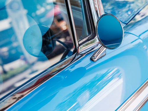 Free Close-up of a blue vintage car showcasing chrome details and reflections captured on a sunny day. Stock Photo