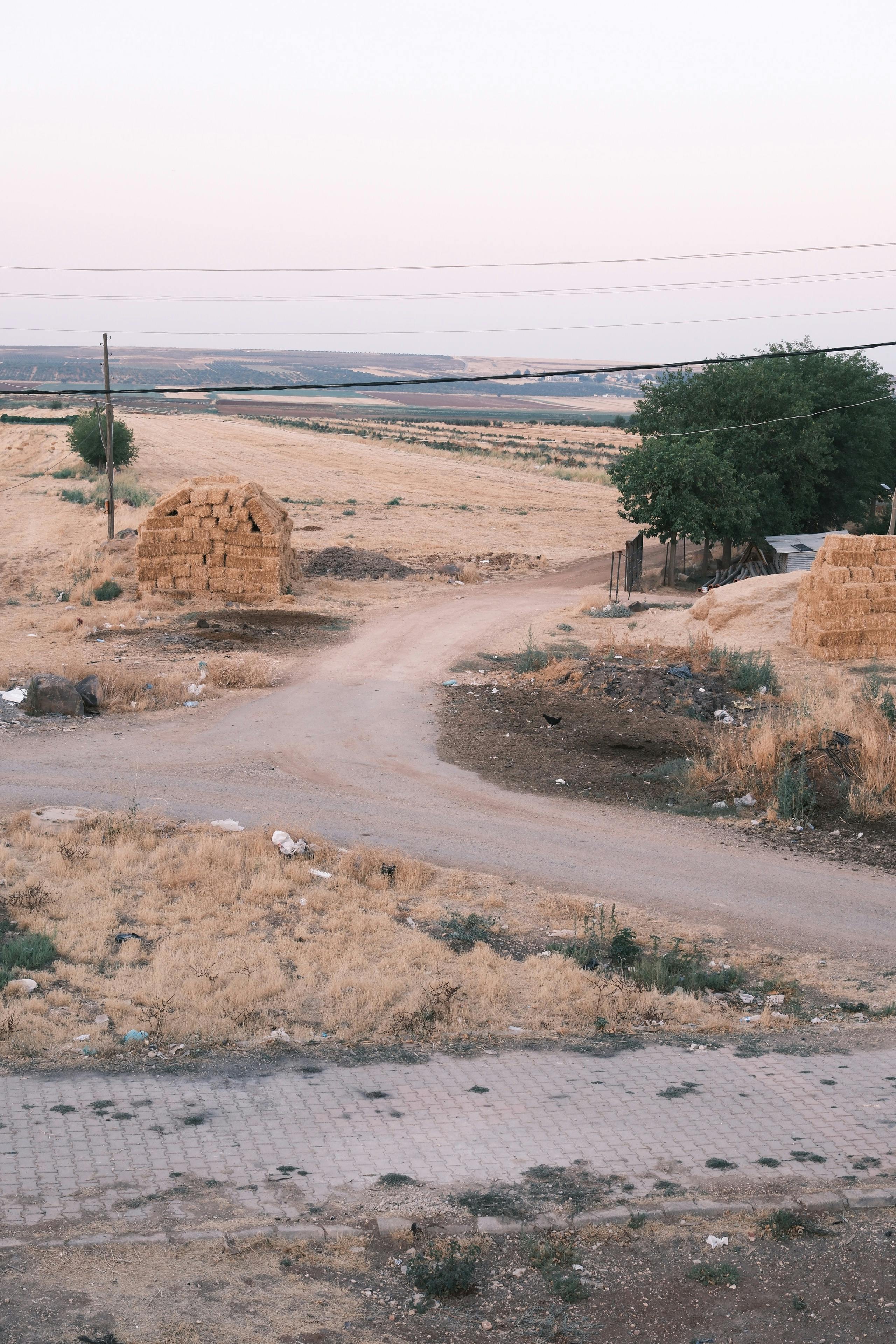 a dirt road with a sign that says road to the village