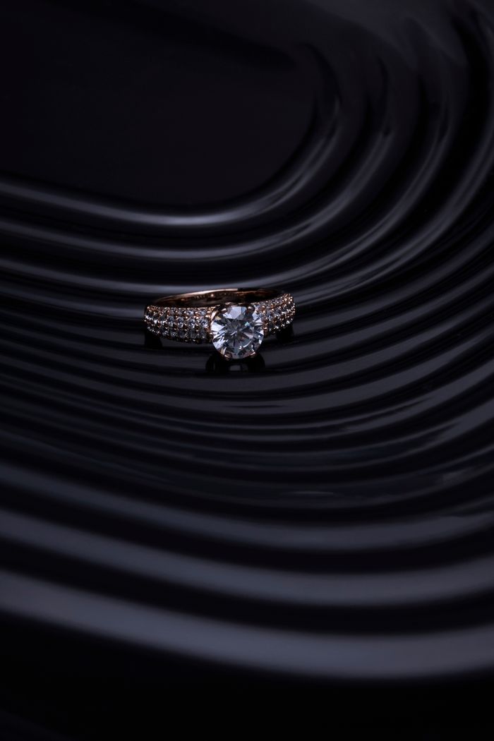 Diamond ring photographed on a black rippled surface