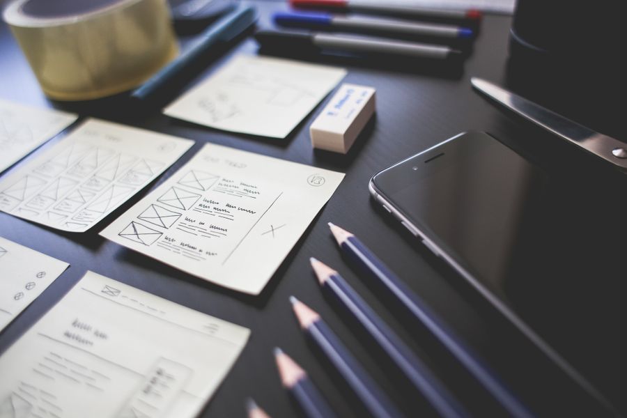 Wireframe sketches and pencils on a desk — photo by Pixabay on Pexels
