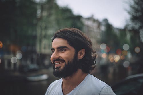 Selective Focus Photography of a Smiling  Man Wearing a V-neck Shirt