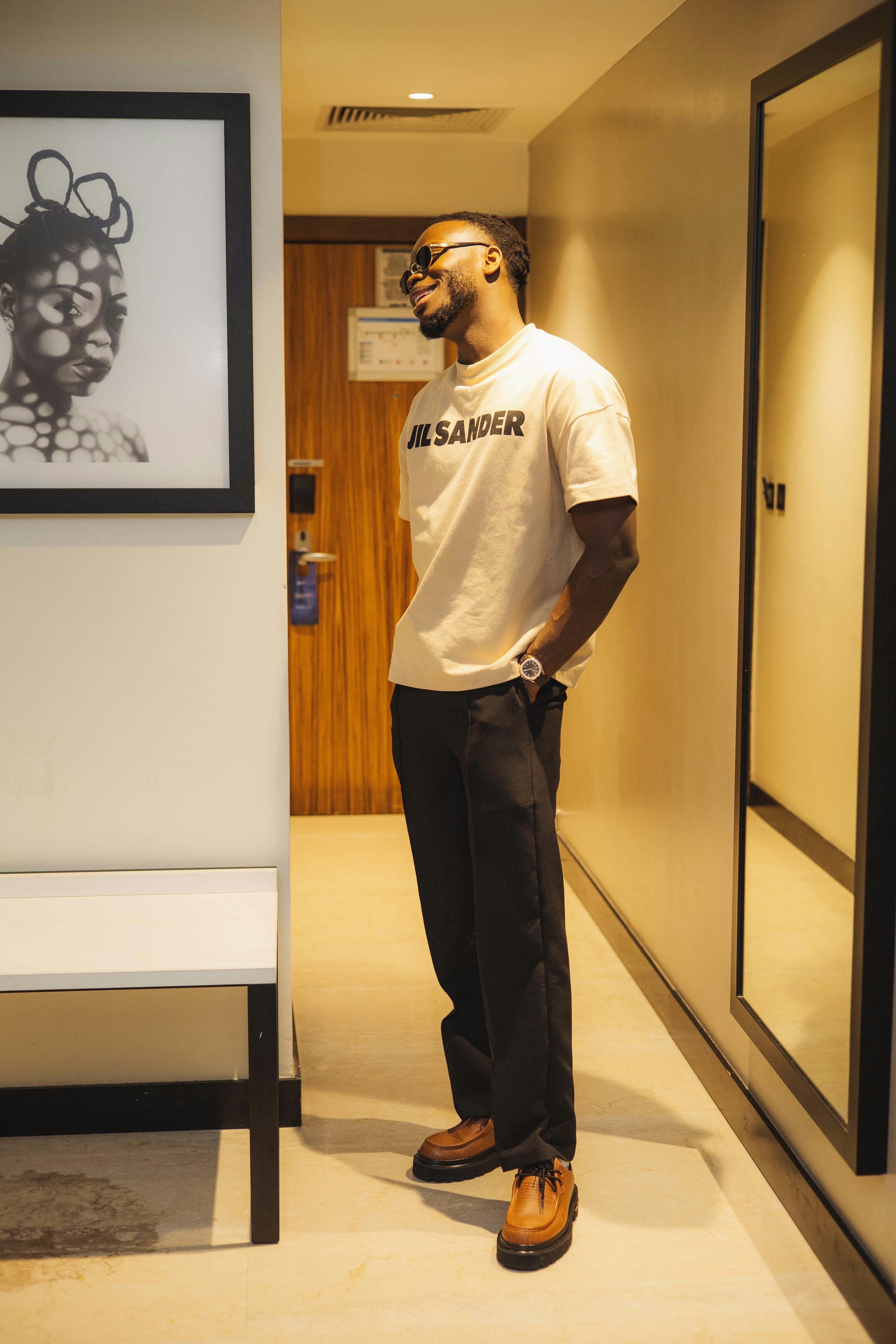 a man standing in a hallway with a picture of a woman