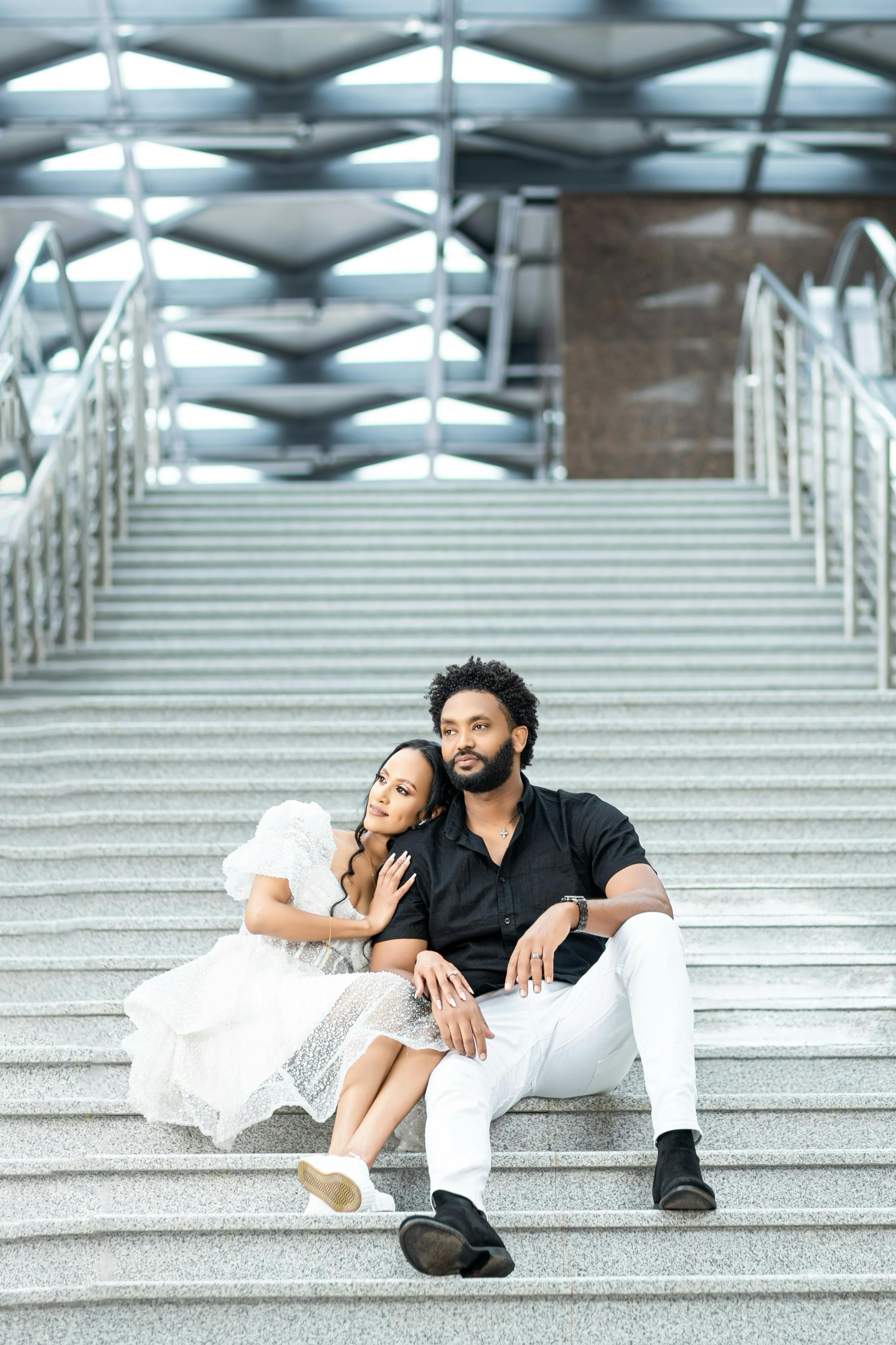 A fashionable couple embracing on a modern staircase, highlighting urban Ethiopian style.