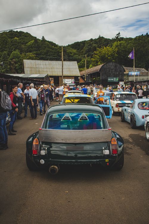 Free A bustling scene of a car show featuring vintage vehicles and a crowd of enthusiasts on a sunny day. Stock Photo