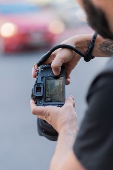 Close-up of a man photographing cityscape with DSLR camera outdoors.