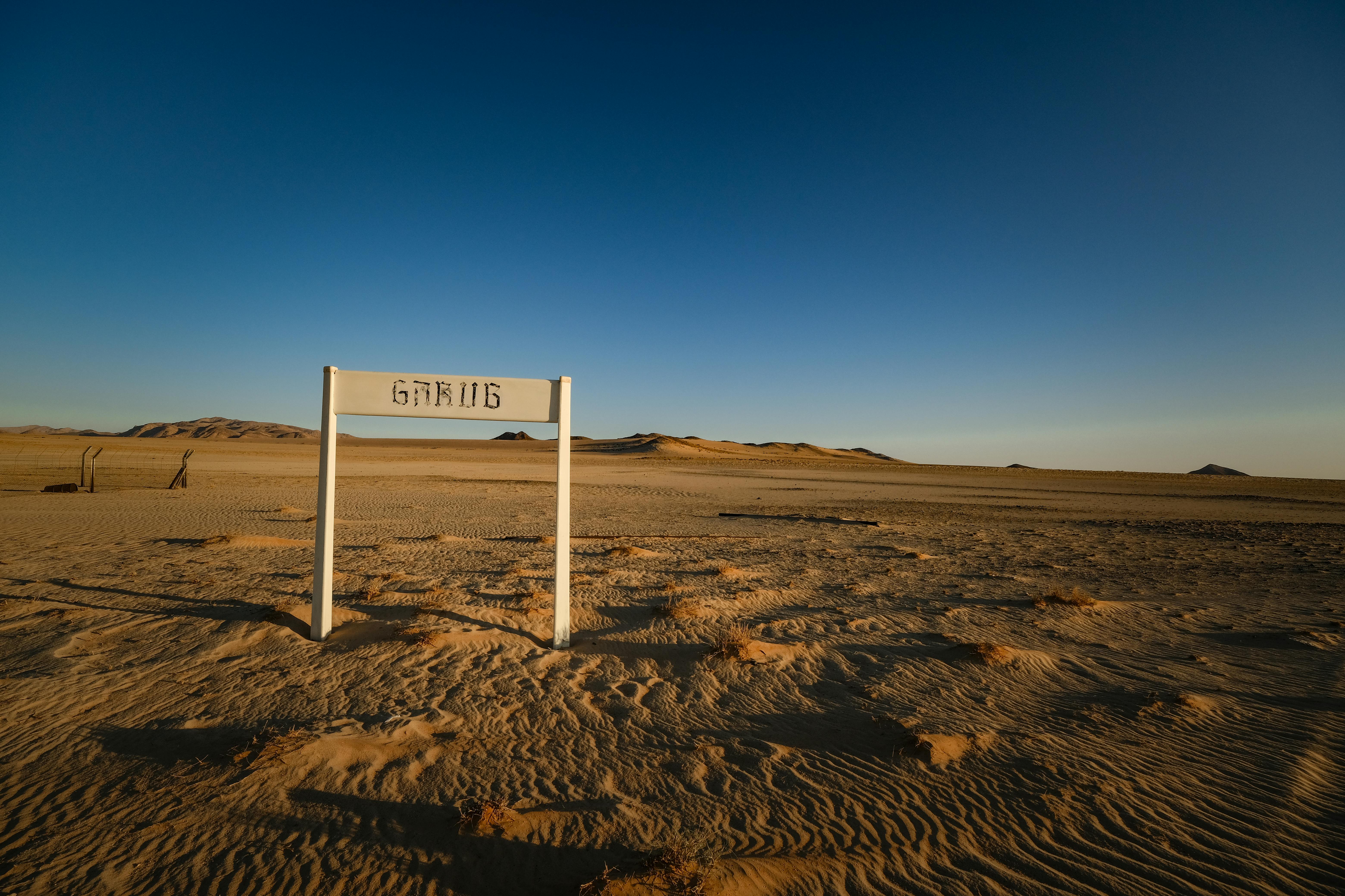 a sign in the middle of a desert with no people